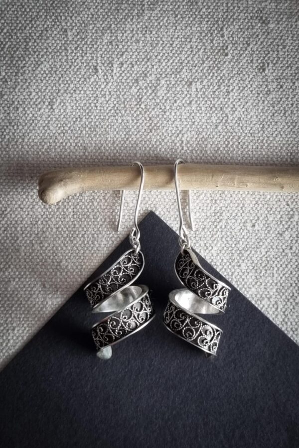 boucles d'oreilles en argent filigrané sur fond noir