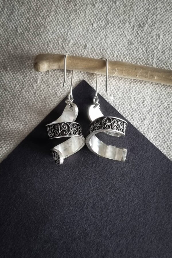 boucles d'oreilles en argent filigrané sur fond noir