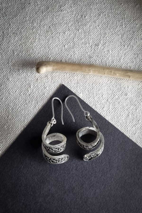 boucles d'oreilles en argent filigrané sur fond noir