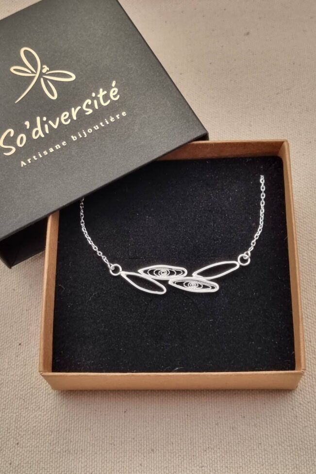collier en argent avec motif de feuilles en simple contour ou avec filigrane, posé dans son étui noir et marron