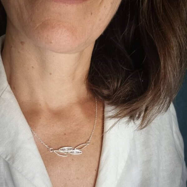 collier en argent porté avec en son centre un motif de feuilles simple contour ou remplies de filigrane