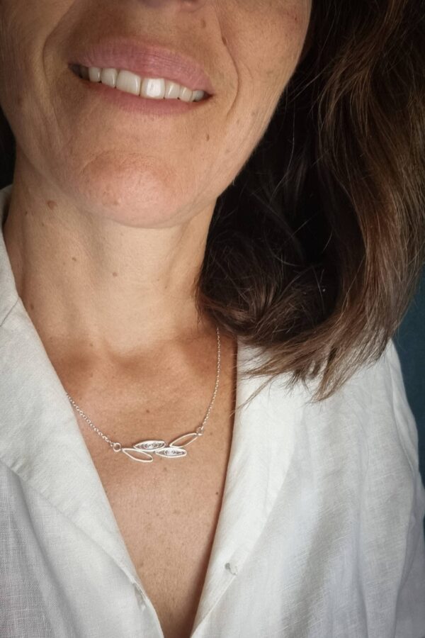 collier en argent porté avec en son centre un motif de feuilles simple contour ou remplies de filigrane